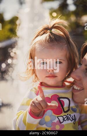 ODESSA, UKRAINE - 5 OCTOBRE 2014 : gros plan portrait d'un beau petit bébé, petite fille blonde dans le pull en couleur Disney Daisy Duck chez les mères Banque D'Images