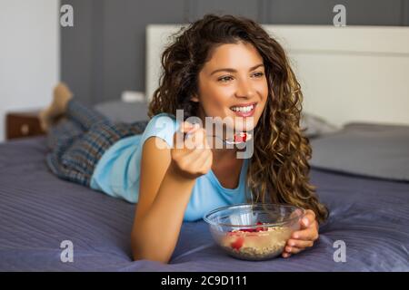 Belle femme aime manger des céréales pour le petit déjeuner. Banque D'Images