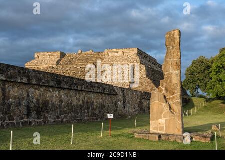 Stela 18 et les pyramides du Groupe IV au lever du soleil dans les ruines de Zapotec précolombiennes de Monte Alban à Oaxaca, Mexique. Un site classé au patrimoine mondial de l'UNESCO. Banque D'Images