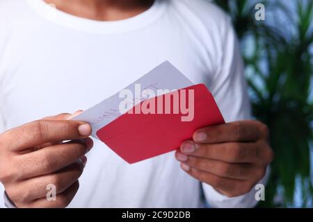 gros plan de la main d'homme tenant l'enveloppe rouge. Banque D'Images