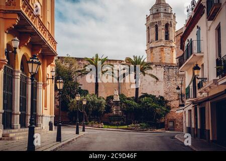 Rue déserte dans la vieille ville de Sitges avec le clocher de au loin, Plaça de l'Ajuntament, Sitges, Catalogne, Espagne Banque D'Images