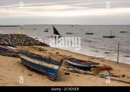 Weaterd s'étend sur la plage de sable de Maputo, au Mozambique, avec d'autres bateaux quittant le petit port de pêche en début de matinée Banque D'Images