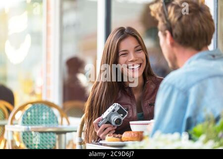 Couple au café style de vie. Les jeunes touristes mangent le petit-déjeuner à la table du restaurant devant la terrasse du bistro parisien dans la ville européenne. Asiatique Banque D'Images
