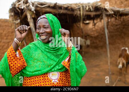 Une agricultrice africaine nourrit son petit troupeau de moutons et de chèvres à l'extérieur de sa maison, dans la région de Tahoua, au Niger, en Afrique de l'Ouest. Banque D'Images