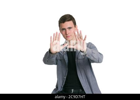 Un jeune homme dans une chemise de Manatee, un t-shirt noir et un pantalon, isolé sur blanc, avec une main ouverte faisant signe d'arrêt Banque D'Images