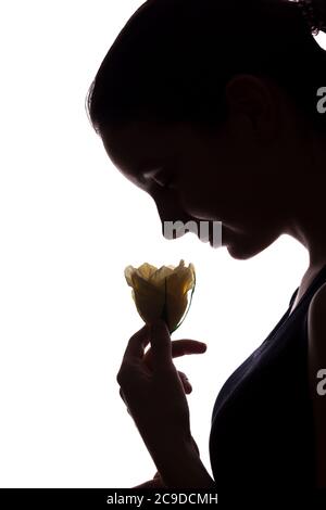 Jeune femme regarde devant avec fleur - vertical, silhouette isolée d'une vue latérale Banque D'Images