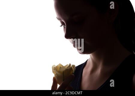 Jeune femme regarde devant avec fleur - silhouette horizontale isolée d'une vue latérale Banque D'Images