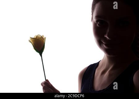 Jeune femme regarde devant avec fleur - silhouette horizontale isolée d'une vue latérale Banque D'Images