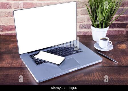 Nouveau smartphone sur le clavier de l'ordinateur portable au-dessus de la table. Banque D'Images