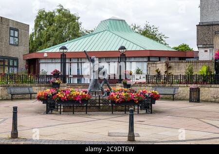 Jackie Crookston Memorial statue (David Annand), Tranent, East Lothian, Écosse, Royaume-Uni avec Keep Scotland belles fleurs Banque D'Images