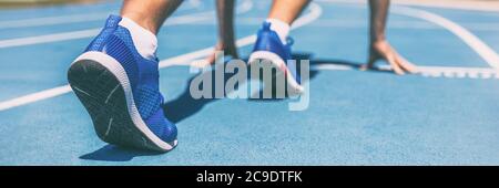 Sprinter attendant le début de la course sur les pistes de course au stade en plein air. Sport et forme physique coureur homme athlète sur piste bleue avec des chaussures de course à pied Banque D'Images