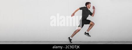 Homme de course entraînement de coureur faire des courses de ville en plein air sprint le long de fond de mur. Vie urbaine saine et active. Athlète masculin faisant sprint hiit Banque D'Images