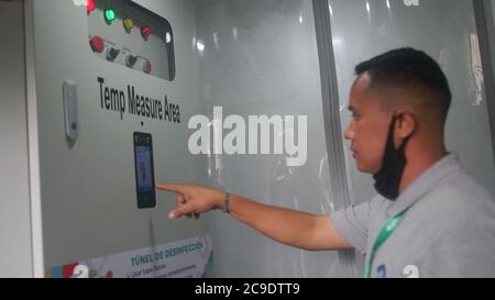 30 juillet 2020, Venezuela, Caracas: Un homme avec un masque facial en dessous a sa température mesurée à l'entrée du supermarché iranien 'Megasis'. Le supermarché, qui a ouvert ses portes cette semaine, est le premier magasin d'alimentation iranien au Venezuela, où un navire transportant des marchandises iraniennes est arrivé à la mi-juin. En raison d'un manque de devises étrangères, le Venezuela ne peut guère importer de la nourriture, des médicaments et des nécessités quotidiennes. Les sanctions américaines contre le gouvernement du président Maduro rendent les importations plus difficiles. « l'Iran, ainsi que tous les pays du monde, a droit au libre-échange », a déclaré l'ambassadeur d'Iran Banque D'Images