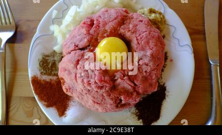 Bœuf cru servi sous forme de steak tartar, d'œufs de rangée et d'épices Banque D'Images