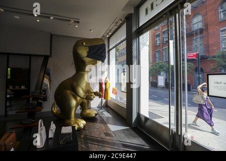 (200730) -- NEW YORK, le 30 juillet 2020 (Xinhua) -- UNE sculpture de dinosaure avec masque facial est vue dans un magasin de SoHo à New York, aux États-Unis, le 30 juillet 2020. L'économie américaine a connu la plus forte contraction depuis des décennies entre avril et juin alors que le pays s'est mis aux prises avec les retombées des blocages de la COVID-19, indiquant la profondeur et la gravité de la récession provoquée par une pandémie. L'économie américaine s'est contractée à un taux annuel de 32.9 pour cent au deuxième trimestre, a rapporté jeudi le département américain du commerce. C'était le déclin le plus profond depuis que le gouvernement a commencé à tenir des registres en 1947. (Xinhua/Wang Banque D'Images