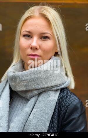 Jeune belle femme blonde contre vieux mur en métal rouillé Banque D'Images