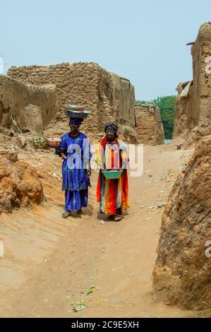 Deux femmes traversent le village de Segoukoro (tribu Bambara) près de la ville de Segou, dans le centre du Mali, en Afrique de l'Ouest. Banque D'Images