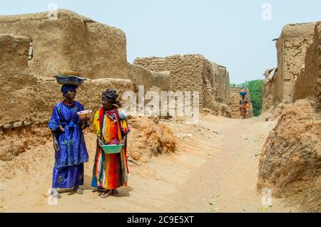 Deux femmes traversent le village de Segoukoro (tribu Bambara) près de la ville de Segou, dans le centre du Mali, en Afrique de l'Ouest. Banque D'Images