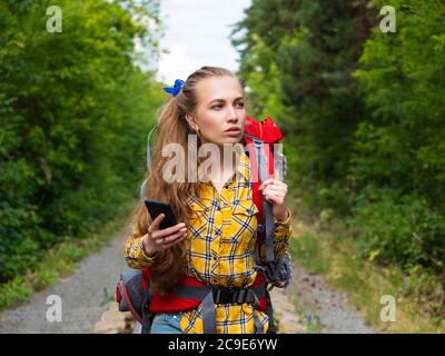 Portrait d'une randonneur perdue dans la forêt. Elle utilise la carte GPS mobile. Banque D'Images