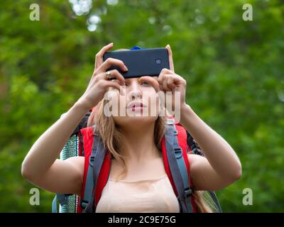 Une randonneur dans la forêt fait une photo avec son téléphone. Concept d'écotourisme. Banque D'Images