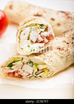 Shawarma traditionnel avec poulet. Rouler dans une tortilla de blé avec des légumes, de la salade et du poulet. Cuisine turque. Tir vertical Banque D'Images