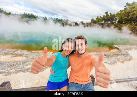 New Zealand Happy tourist couple faisant le pouce vers le haut à la célèbre destination de voyage d'attraction. Piscine au champagne, Waiotapu. Zone géothermique active, à Taupo Banque D'Images