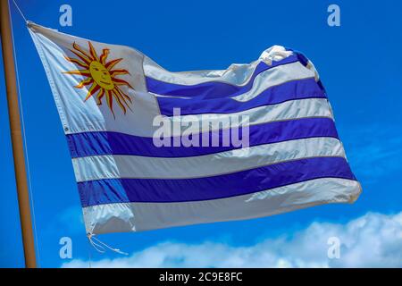 Drapeau de l'Uruguay , souffle dans le vent avec le ciel bleu et les nuages sur le fond Banque D'Images