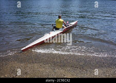 Un homme lance son kayak sur une rampe d'accès pour bateaux sur la rivière Willamette, dans le lac Oswego, en Oregon. Banque D'Images