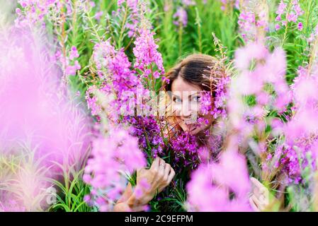 Portrait extérieur d'une belle femme blonde d'âge moyen dans un champ avec des fleurs Banque D'Images