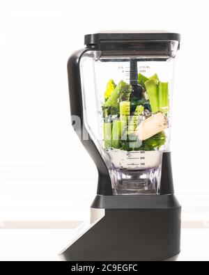 Mixeur avec ingrédients gros plan sur fond blanc. Recette de smoothie aux épinards et au céleri. Banque D'Images