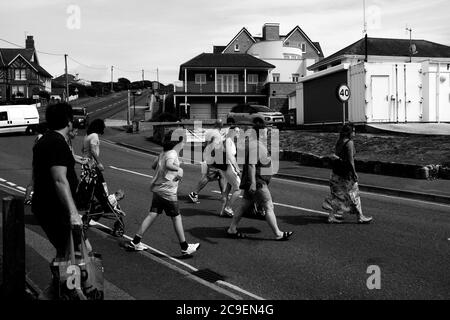 Un groupe de personnes traversant la route de Freshwater Bay sur l'île de Wight. Banque D'Images