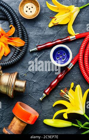 Narguilé asiatique fumant avec tabac à fleurs parfumé. Chicha au goût de Lily Banque D'Images