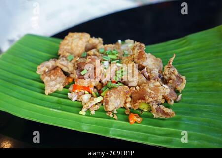 Gros plan de piment et d'ail servis avec du ventre de porc croustillant et frits Banque D'Images