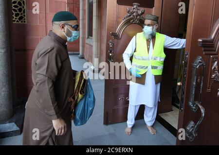 Les fidèles observent les distances sociales à leur arrivée à la grande mosquée Bradford de Bradford, dans le West Yorkshire, le premier jour d'Eid, l'une des zones où de nouvelles mesures ont été mises en œuvre pour prévenir la propagation du coronavirus. Des règles plus strictes ont été introduites pour les habitants du Grand Manchester, de certaines régions du Lancashire oriental et du West Yorkshire, interdisant aux membres de différents ménages de se rencontrer à l'intérieur. Banque D'Images