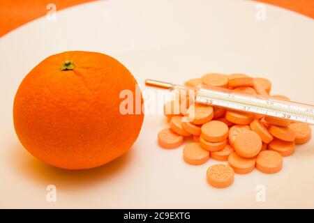 Thermomètre à mercure avec comprimés et orange sur fond blanc - vitamine, protection contre la grippe pendant la quarantaine, coronavirus, covid19 Banque D'Images