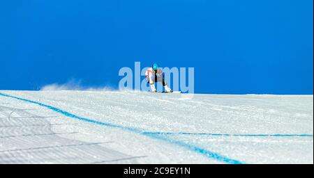 homme skieur de montagne sur la piste de slalom géant dans le ciel bleu d'arrière-plan Banque D'Images