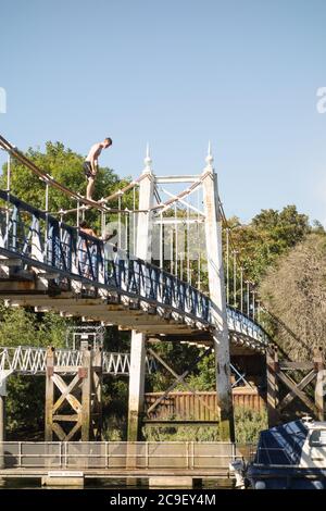 Garçons sautant de la passerelle Teddington Lock vers la Tamise, Teddington, Angleterre, Royaume-Uni Banque D'Images