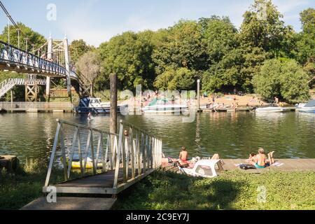 Bains de soleil lors d'une journée d'été à côté de la passerelle Teddington Lock sur la Tamise, Teddington, Angleterre, Royaume-Uni Banque D'Images