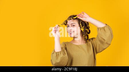 bonheur d'enfance. bonne fille dans les cheveux curlers jouant salon de coiffure. Conseils faciles pour la coiffure des enfants. Outils de coiffure et accessoires de cheveux. Posture des enfants avec des pillards. Banque D'Images