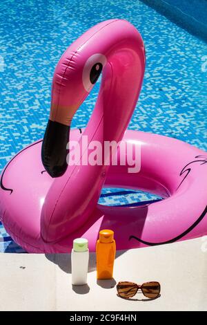 Flamant rose gonflable dans une piscine ensoleillée jour Banque D'Images