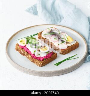 Smorrebrod salé, deux sandwichs traditionnels danois. Pain de seigle noir avec anchois Banque D'Images