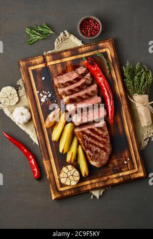 Keto cétogenic Diet steak de bœuf grillé, stripline, tranches de pommes de terre sur la planche à découper Banque D'Images
