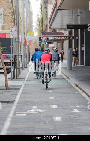 Cyclistes sur une piste cyclable dédiée le week-end du matin à Kent Street, Sydney, Australie Banque D'Images