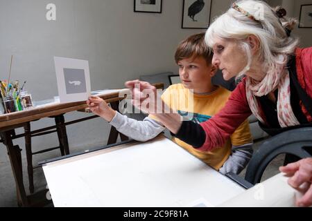 Garçon et enseignant regardant les détails sur le premier modèle pendant Apprendre la gravure dans un atelier de classe d'art en atelier de Carmarthenshire pays de Galles R.-U. KATHY DEWITT Banque D'Images