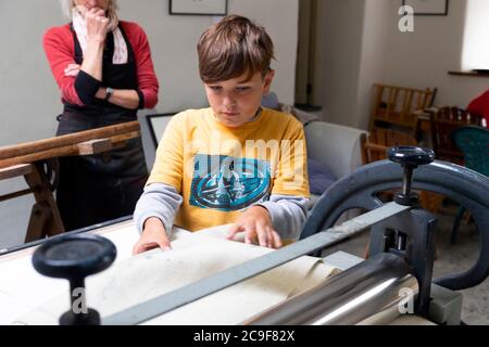 Garçon apprenant à utiliser une presse Littlejohn etchning tout en apprenant la gravure dans un atelier de classe d'art à Carmarthenshire Wales UK KATHY DEWITT Banque D'Images