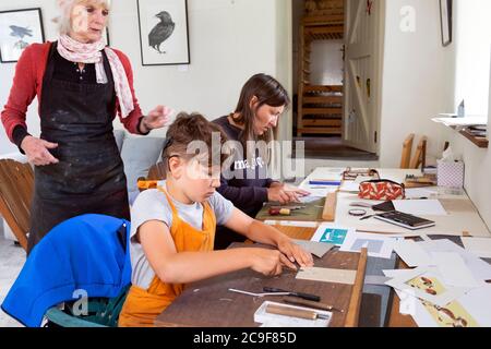 Garçon avec apprentissage de la mère et femme artiste enseignant linocutting et gravure dans un atelier d'art dans Carmarthenshire pays de Galles Royaume-Uni KATHY DEWITT Banque D'Images