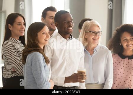 Souriant équipe de divers employés posant pour la photo de l'entreprise dans le bureau Banque D'Images
