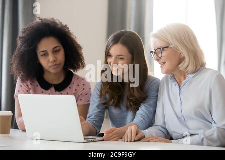 Femme d'affaires mature travaillant sur un projet avec de jeunes collègues Banque D'Images