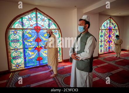 Les fidèles observent les distances sociales à la mosquée Bradford Central le premier jour d'Eid, à Bradford, dans le West Yorkshire, où de nouvelles mesures ont été mises en œuvre pour prévenir la propagation du coronavirus. Des règles plus strictes ont été introduites pour les habitants du Grand Manchester, de certaines régions du Lancashire oriental et du West Yorkshire, interdisant aux membres de différents ménages de se rencontrer à l'intérieur. Banque D'Images