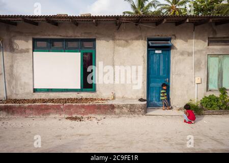 Bodufolhudhoo / Maldives - 17 août 2019 : frère et sœur à la porte de leur maison de toit en ciment et en étain sur l'île des Maldives Banque D'Images